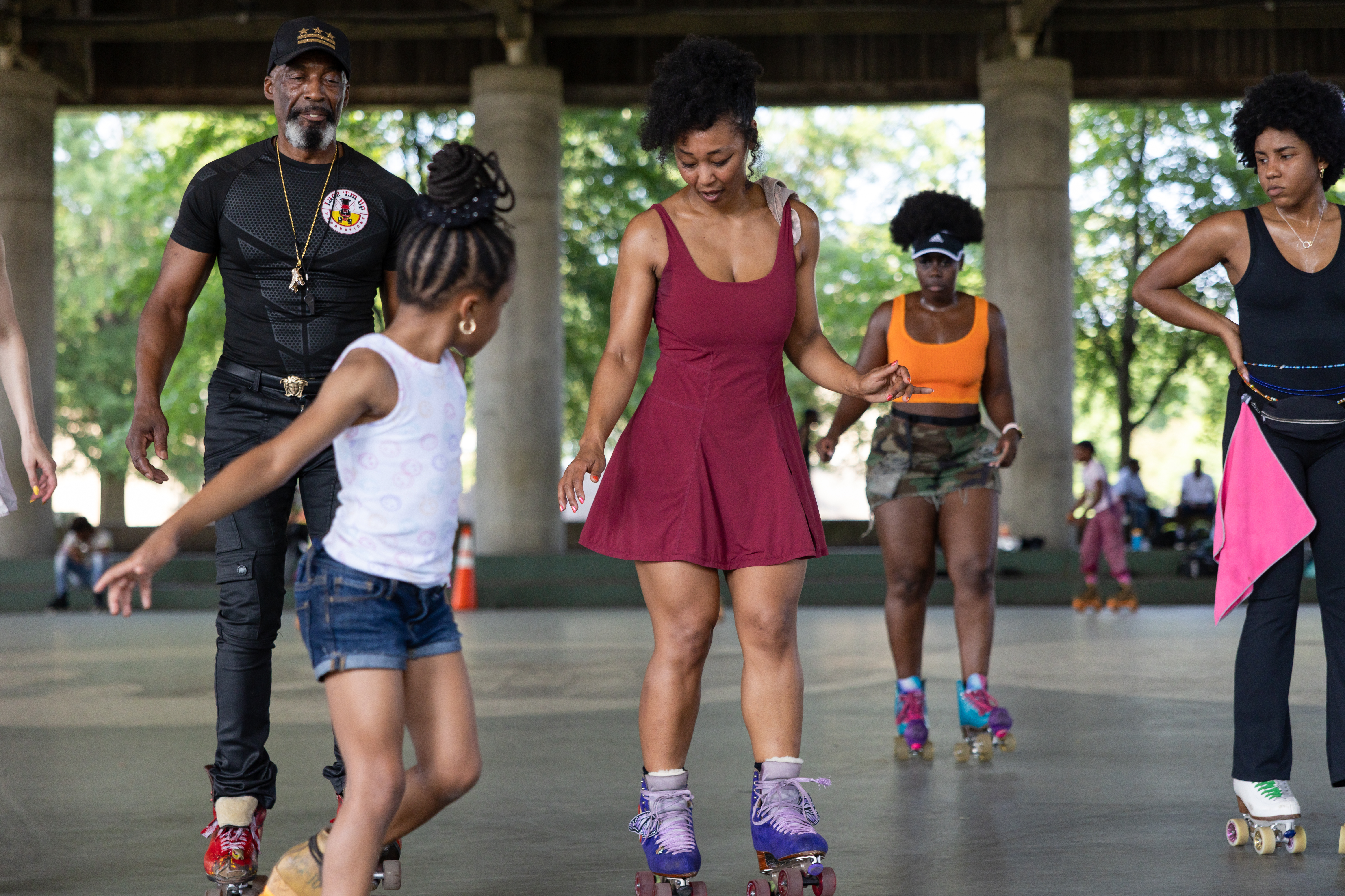 Kenneth "Rollo" Davis, left, shows off his moves as he dances to music played by DJs alongside a group of roller skaters at Anacostia Park Skating Pavilion