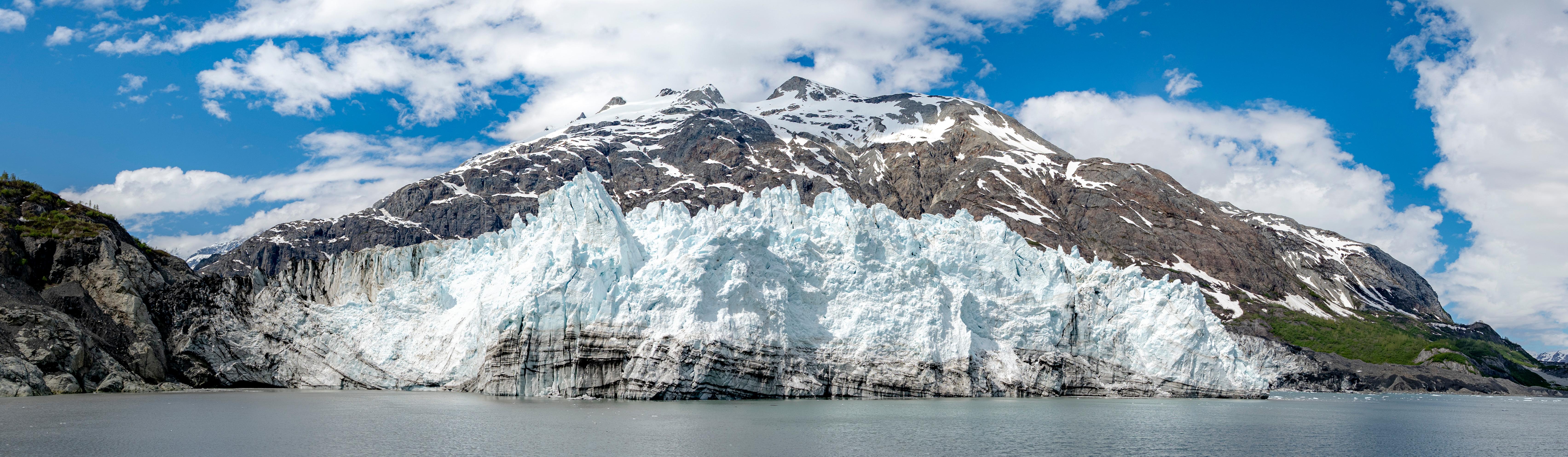 Ocean view of glacier coming down from mountains.