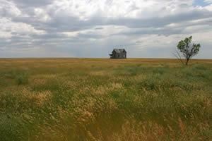 House in the middle of large open prairie.