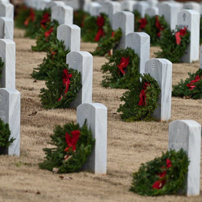 Headstones with decorative wreath laid in front of them.