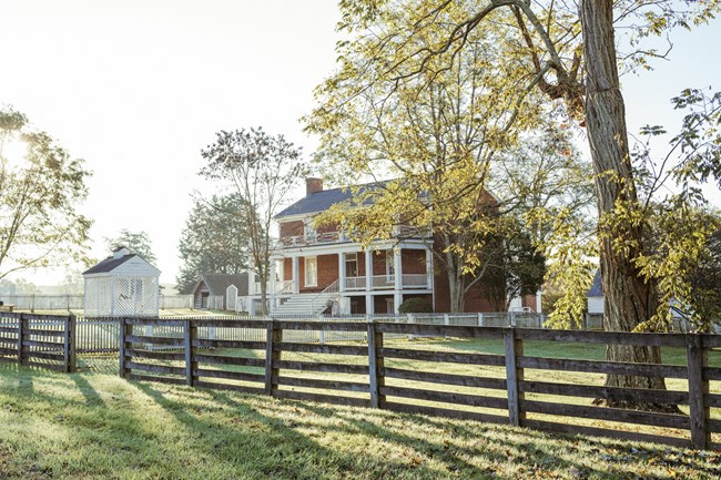 A three story brick house with white pillars