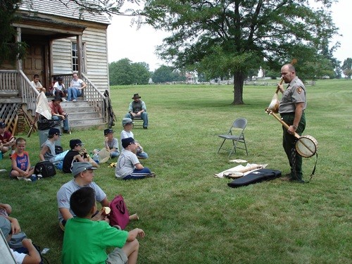 Ranger David Wooldridge demonstrates the banjo and discusses its significance to Appomattox Court House and the cultural exchange involved.