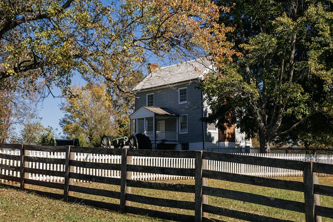 A two-story blue house and white porch.