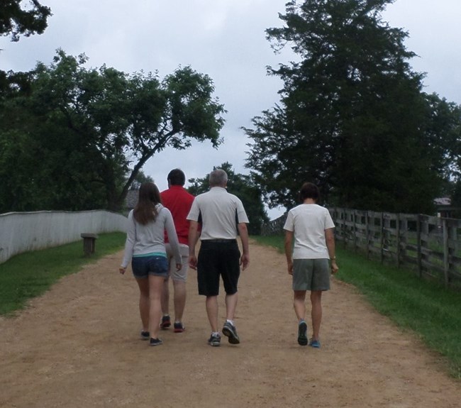 Four visitors going up the hill entering the park.