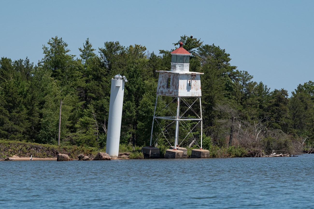 Photograph of historic lighttower on shorline of lake.