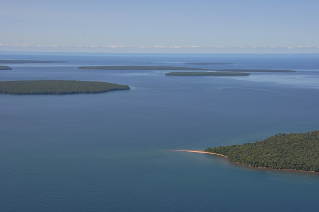 An aerial photo of green forested islands surrounded by blue water.