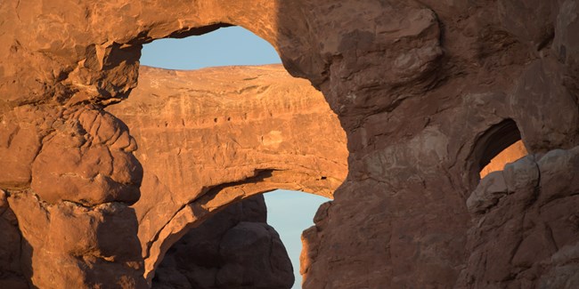 Cropped image showing multiple openings between sandstone rocks creating arches