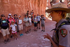 A ranger talks to a group of people along a guided hike