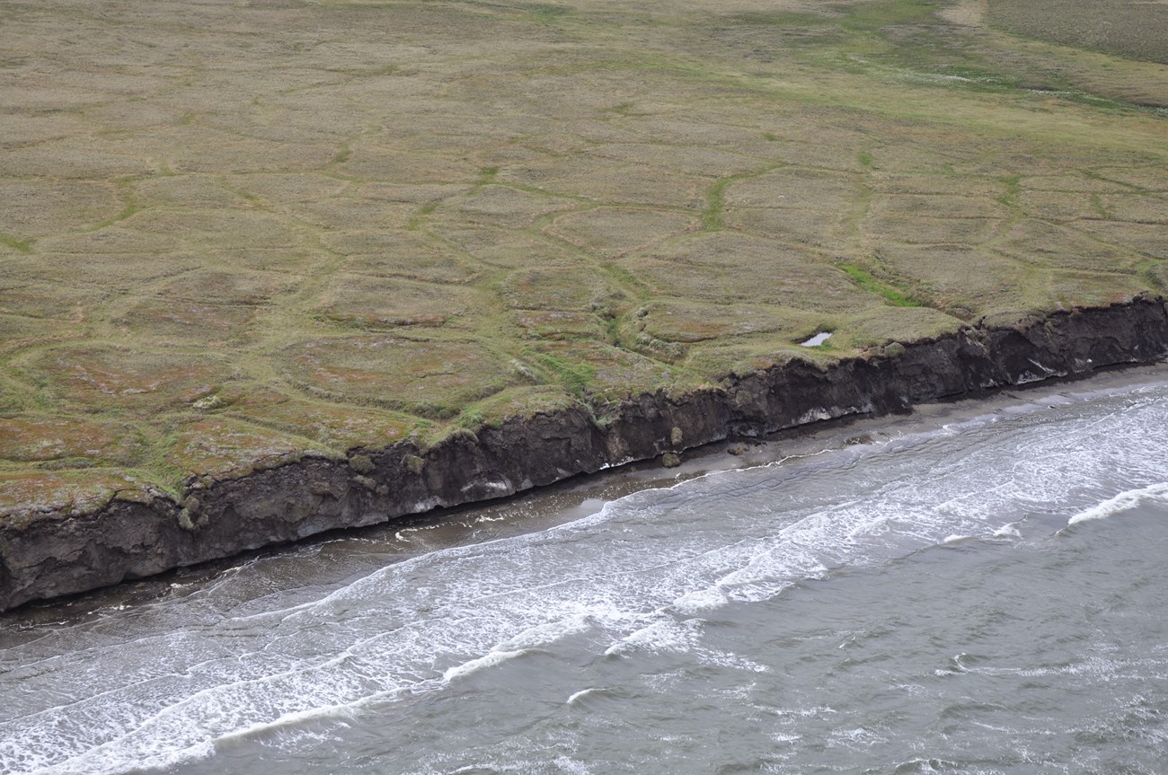 Portions of the coast in Bering Land Bridge National Preserve and Cape Krusenstern National Monument is a steep slope of thawing and eroding permafrost above a narrow beach.