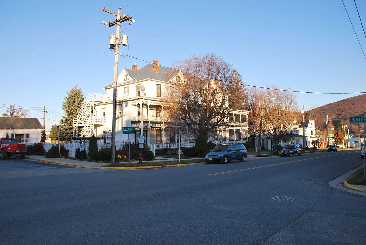 Three story wooden structure on a street corner.