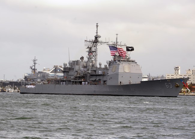 Guided Missile Cruiser with an American flag arrives in San Diego