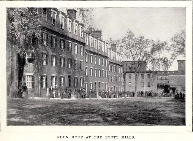 Text reads "Noon hour at the Boott Mills." A line of women file out of a mill toward a boardinghouse