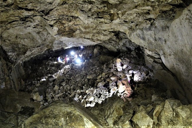 Large room inside Lehman Caves, with staff members in the distance