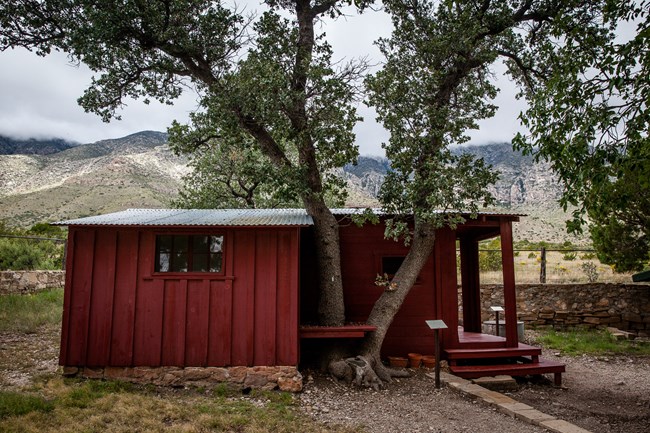 A red frame building inside a stone fenced compound