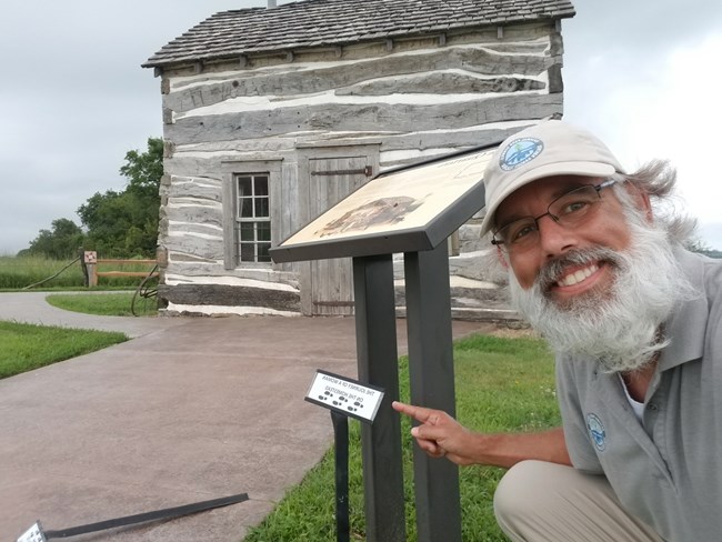 An individual points to a sign showing footprints.