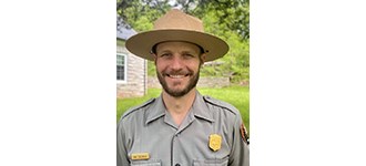 Evan smiling in his NPS uniform and flat hat.