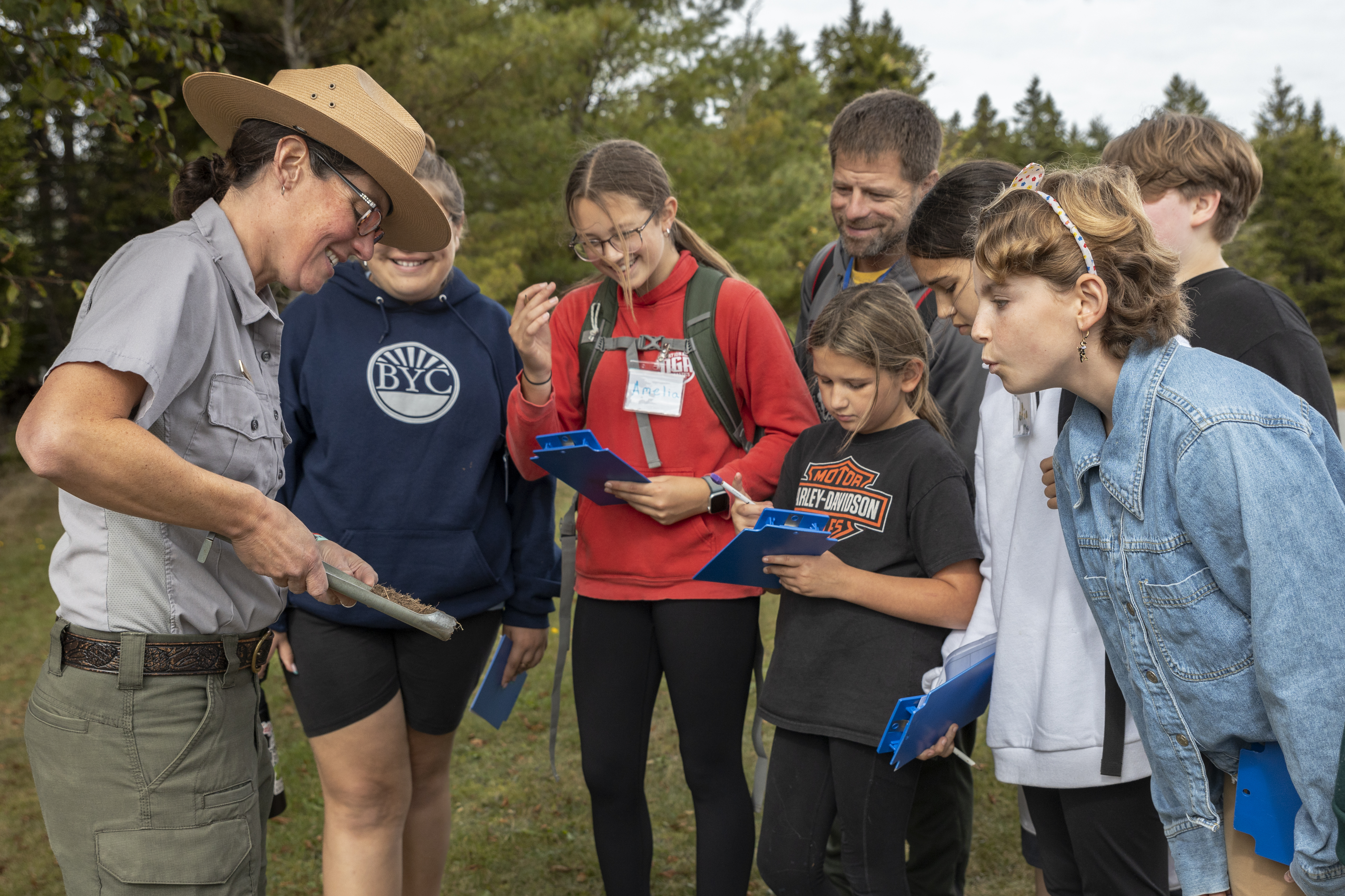 Park ranger talks to visitors about a soil sample.