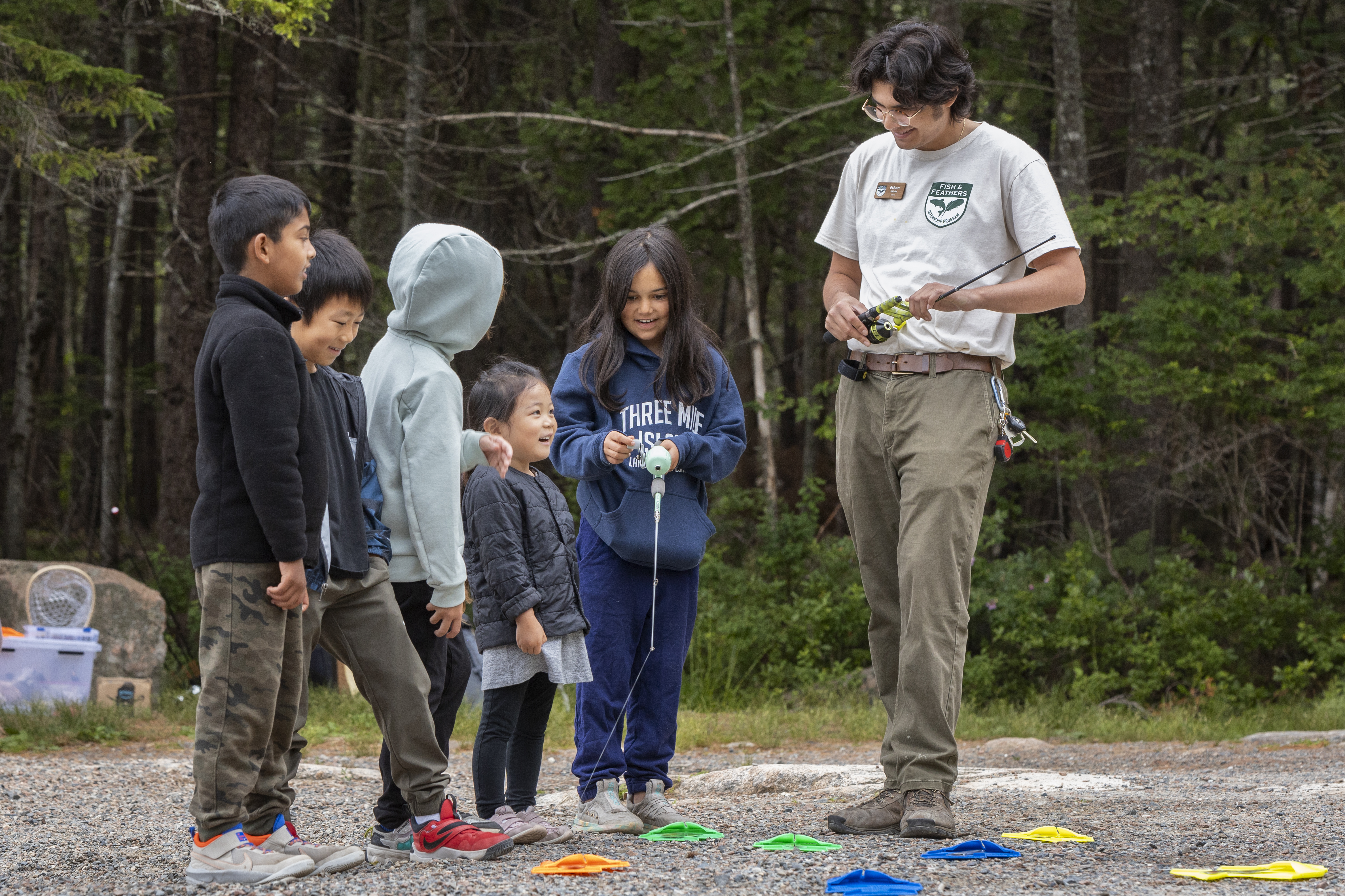 Intern Ethan talking with a group of smiling kids.