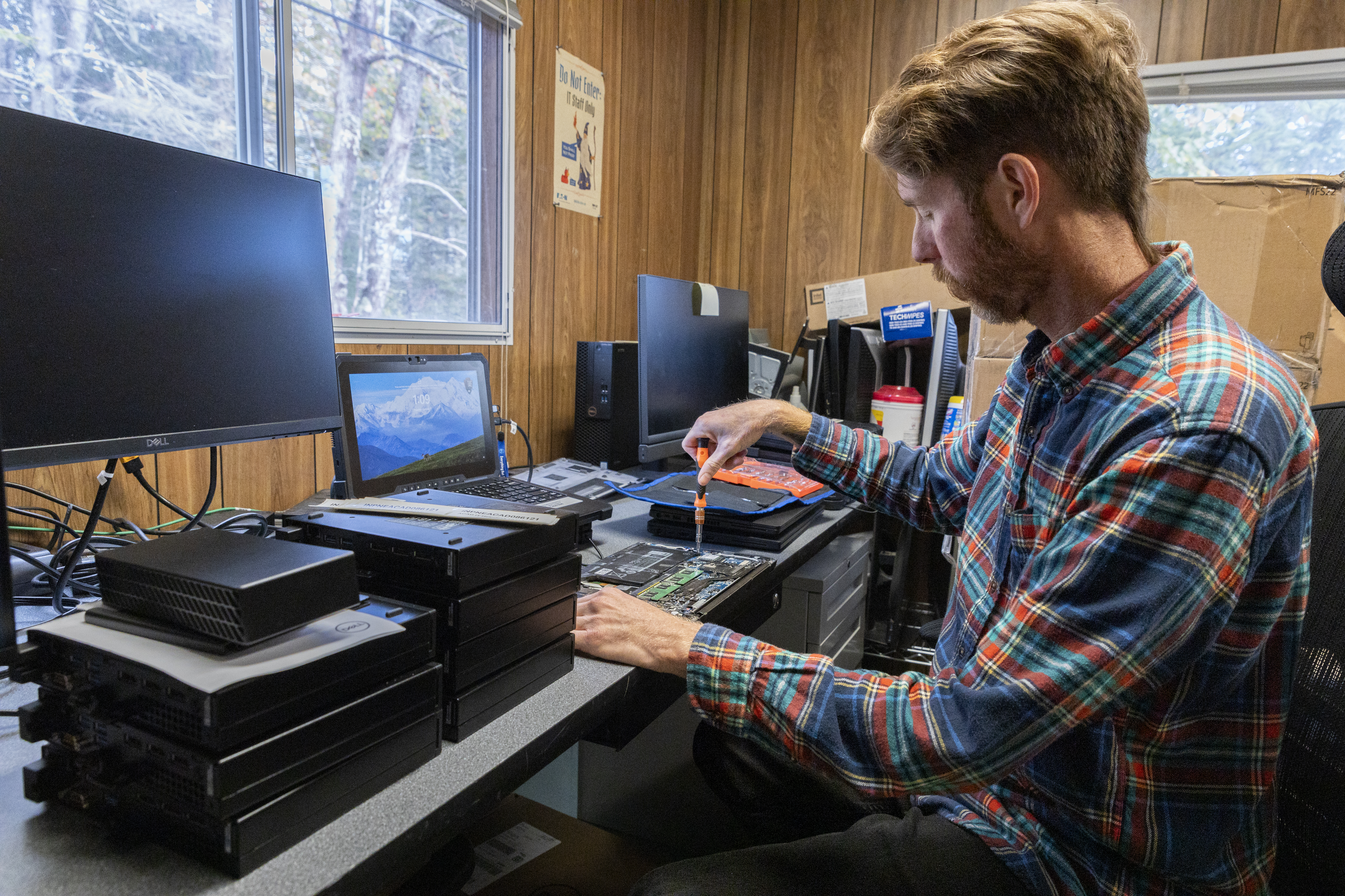 IT worker removes the battery on a laptop.
