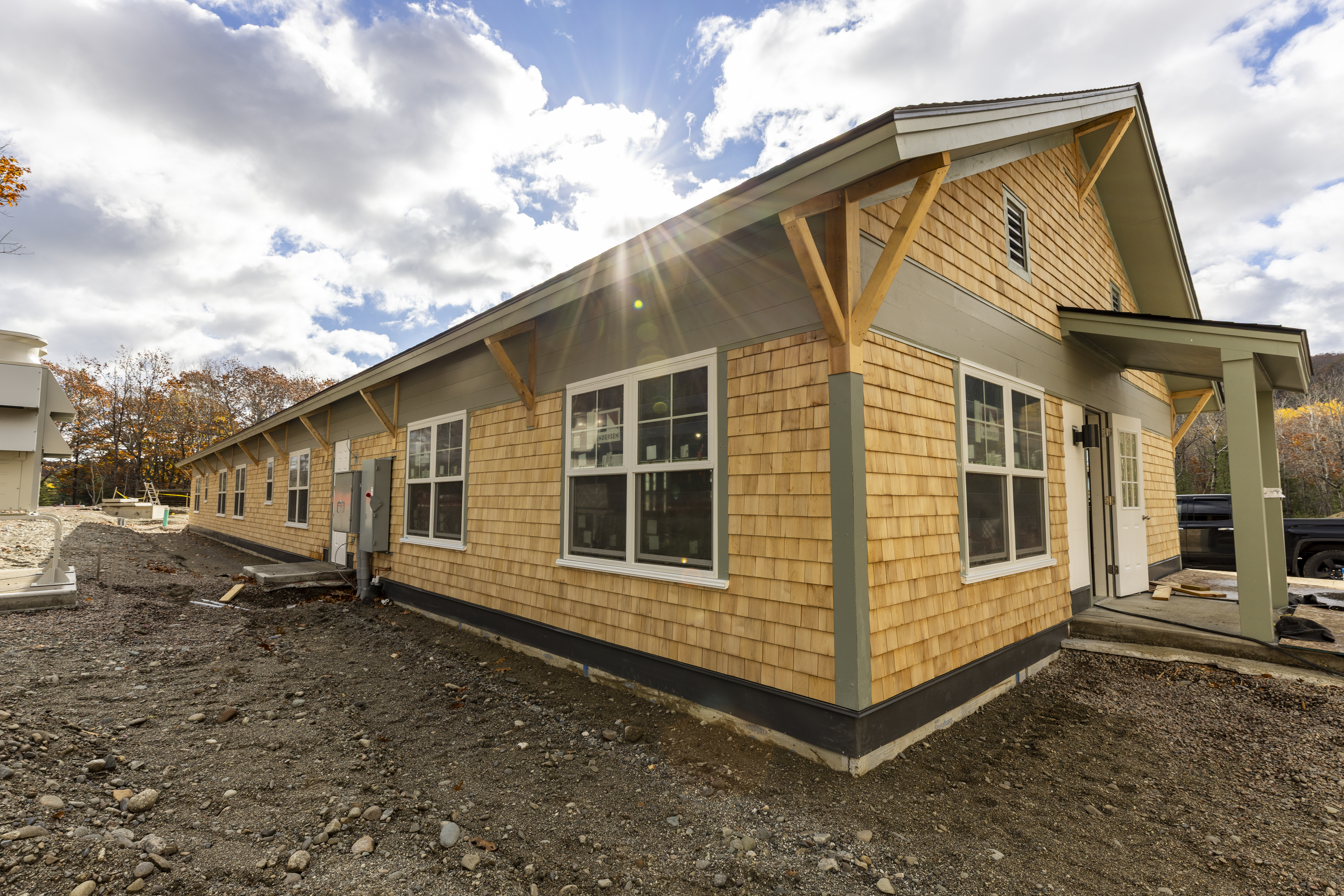 Single story building with wooden shingles and green trim.