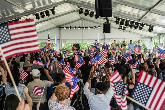 crowd of people inside an event tent waving US flags