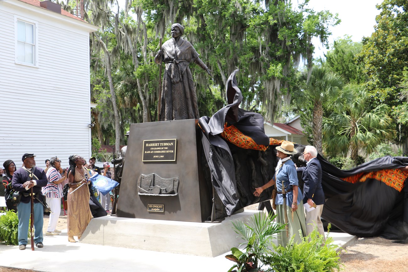 A large bronze statue with Harriet Tubman at the center and soldiers and people at the sides.