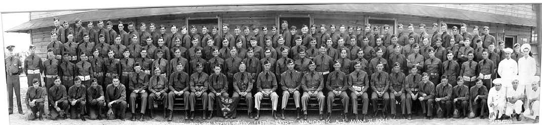 more than one hundred men in military uniforms stand and sit on risers