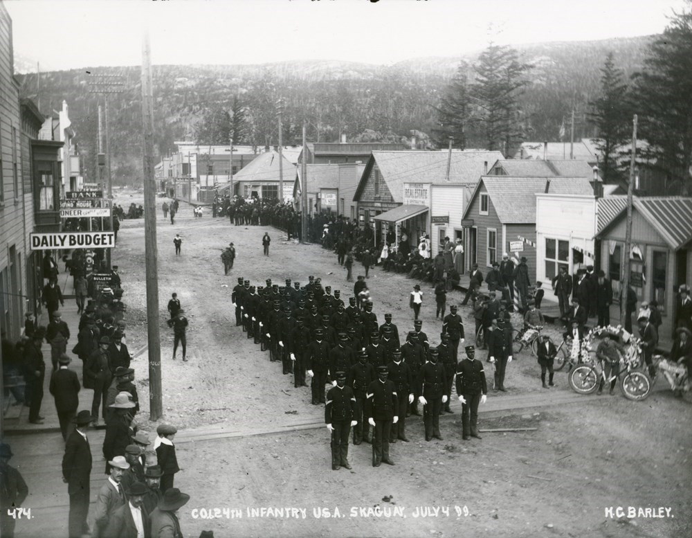 Black and white photo of African American soldiers in military uniforms standing in formation waiting for a parade to start in the late 1890s.