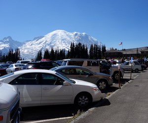A full parking lot in front of a view of Mount Rainier.