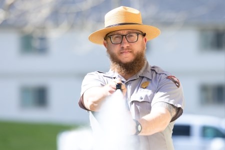 a park ranger spraying bear spray