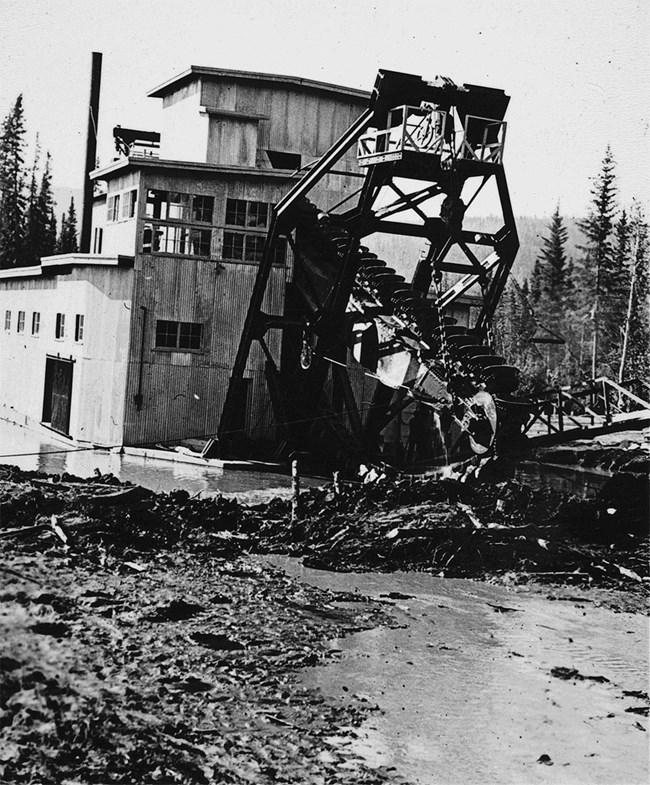 Historical black and white image of a gold dredge.