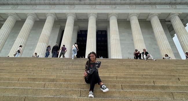 Intern sitting on steps of a memorial