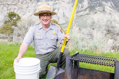 a park ranger near a campfire pit