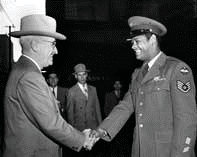 President Truman shaking the hand of an African American soldier