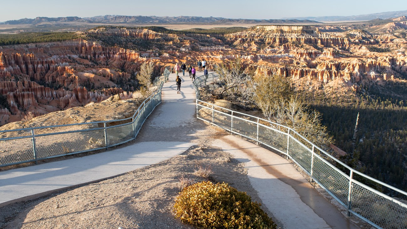 Group of people at the end of a fenced overlook with a spectacular view of Bryce Canyon.