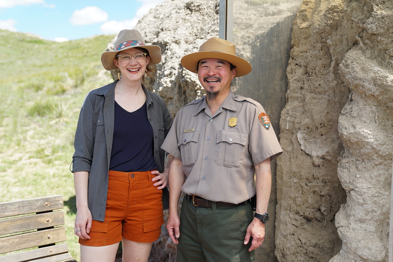 two people standing near a rock outcrop