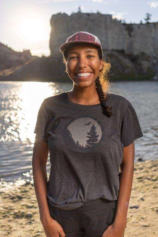 a black woman smiling and wearing a ballcap