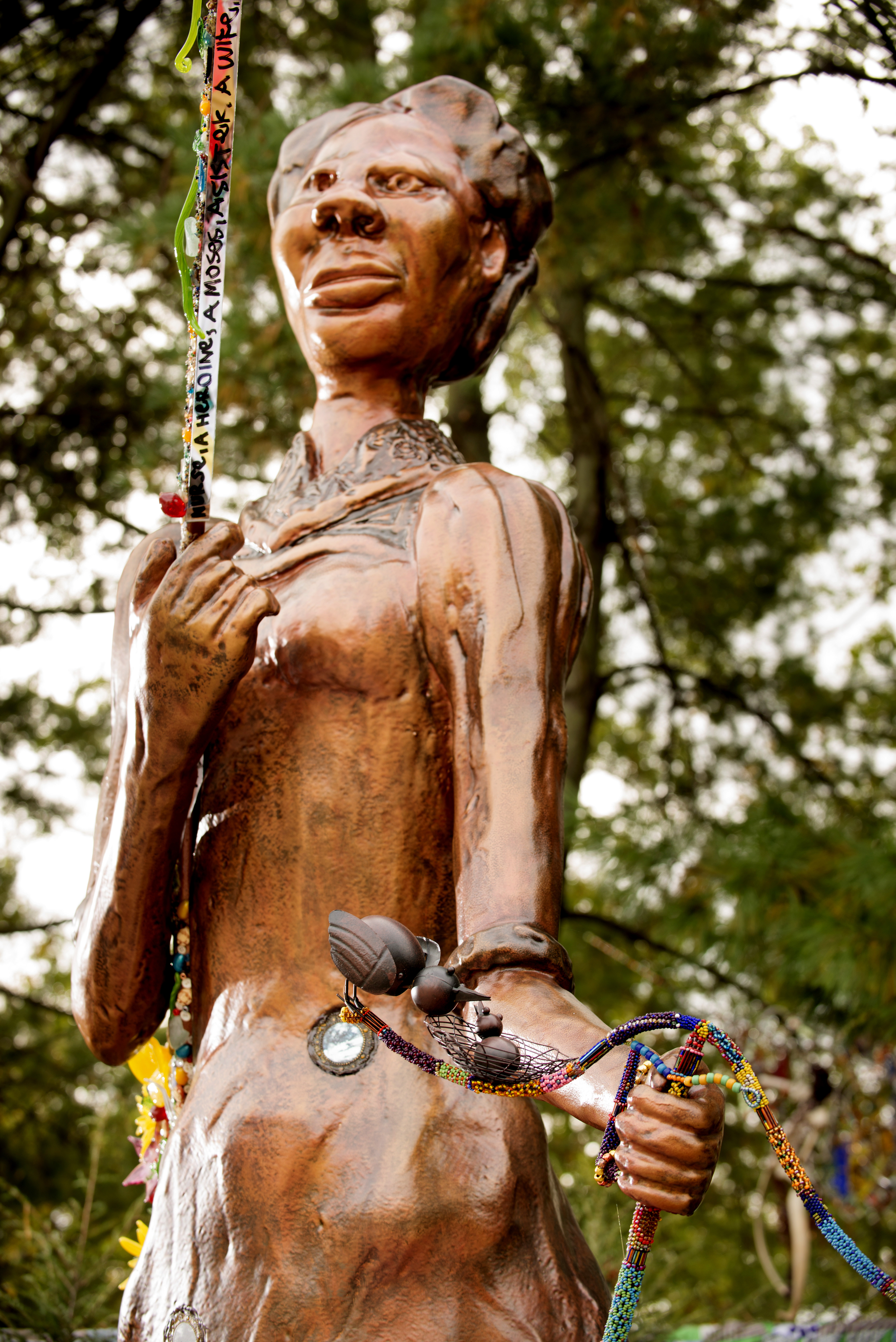 Close up photograph of bronze colored statue of Harriet Tubman facing and standing left.