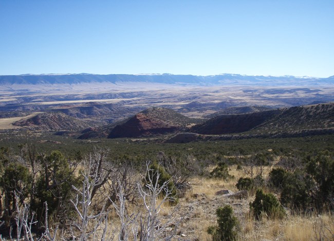 Dry, grass-shrubland stretches for miles across a plain.