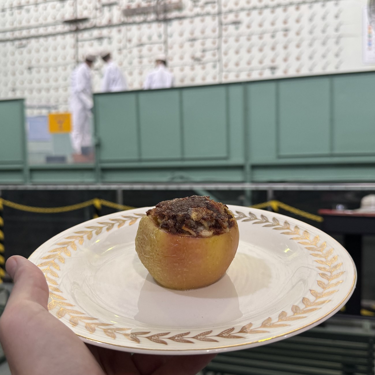 A baked apple with sausage meat on a plate in front of the X-10 Graphite Reactor.