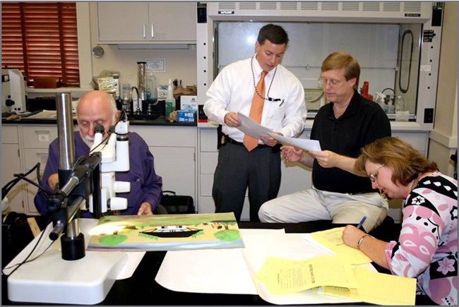 Randy Deaton looks on as Joe Barabe analysis Hunter works at NCPTT.