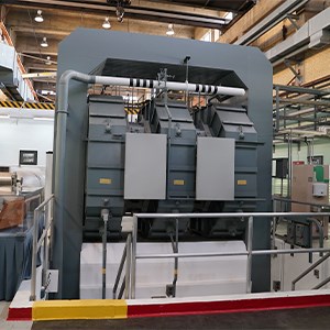 A large, slightly square blue-grey metallic structure in a warehouse.