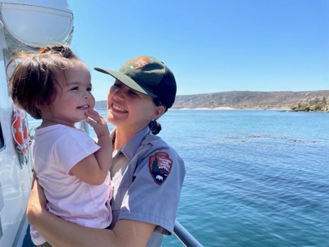 ranger holding child on boat