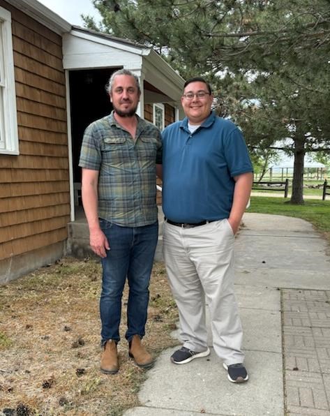 Two men stand together outside