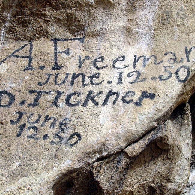 Rock covered in writing: "A. Freeman, June 12, 50" and "D. Tickner, June 12, 50."