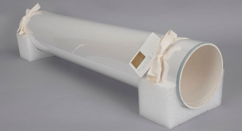 Completed roll tied with twill tape on each end, on polyethylene foam cradle mount ready for storage. Note label on one end.