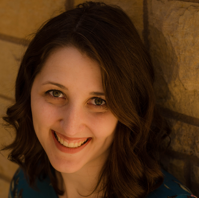 Woman smiling with shoulder length wavy dark hair