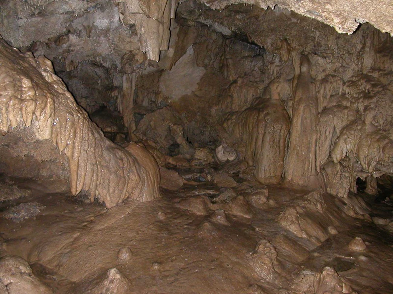 Cave walls made of glistening white, brown, and gray marble formations.