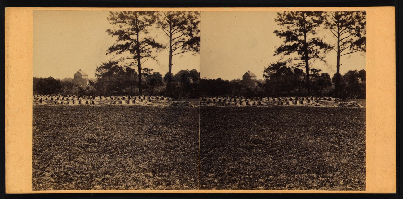 Union burial ground in Charleston, South Carolina, the site of the first Memorial Day observation. In the foreground, a field. In the background, rows of headstones.