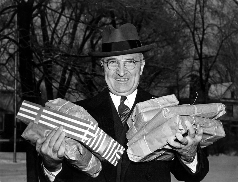 Harry Truman outside, carrying Christmas packages